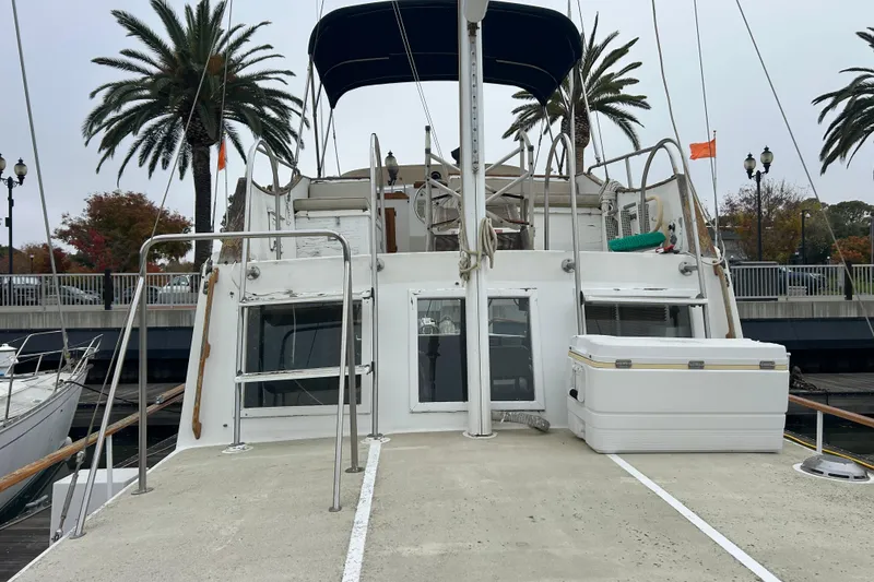 Slide: The Image of 1976 Bristol Trawler docked, featuring deck view with palm trees and overcast sky. - 45