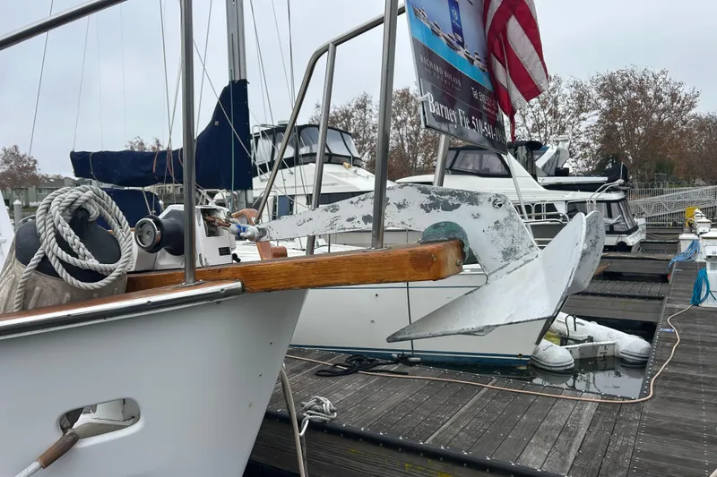 Slide: The Image of 1976 Bristol Trawler docked with anchor and American flag, surrounded by other boats. - 49
