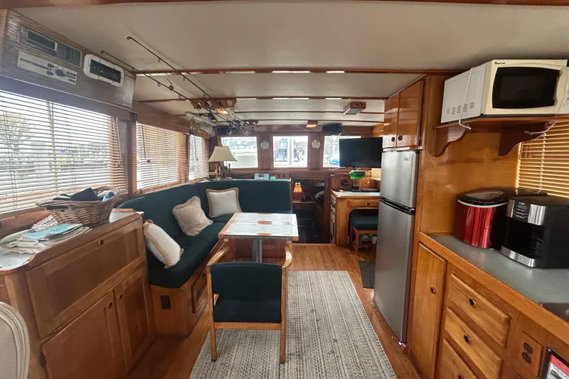 Slide: The Image of 1976 Bristol Trawler interior with cozy seating, dining area, and kitchen appliances. - 5