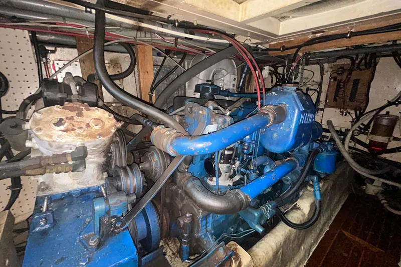 Slide: The Image of Engine room of a 1976 Bristol Trawler, showcasing blue machinery and wiring. - 54