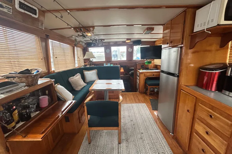 Slide: The Image of Interior of a 1976 Bristol Trawler with cozy seating, wooden cabinetry, and modern appliances. - 6