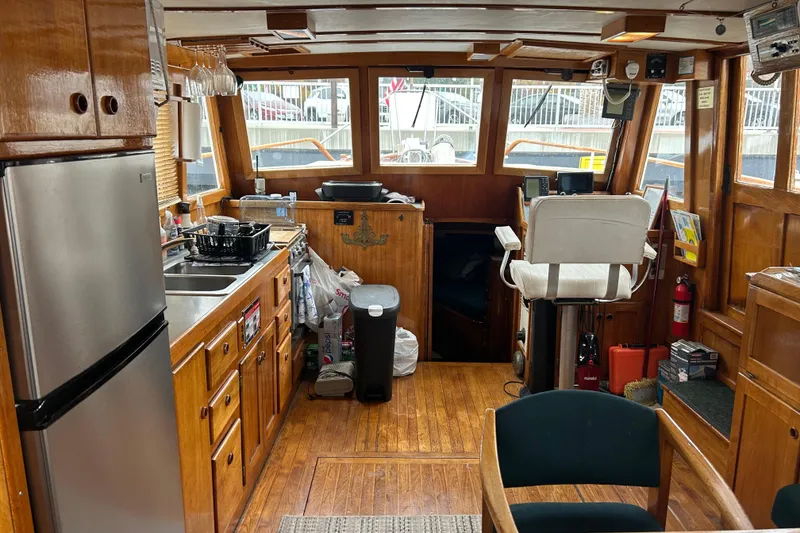Slide: The Image of Interior of a 1976 Bristol Trawler with wooden cabinetry and modern appliances. - 8