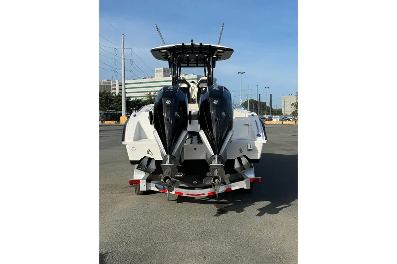 Slide: The Image of 2026 Cape Horn 28XS boat with dual outboard motors on a trailer, parked outdoors. - 4