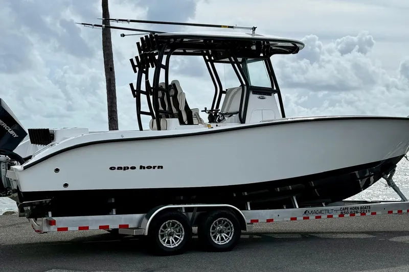 Slide: The Image of 2026 Cape Horn 28XS boat on trailer, parked near ocean under cloudy sky. - 5