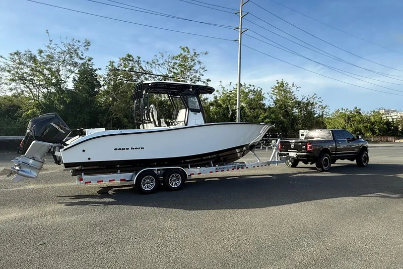 Slide: The Image of 2026 Cape Horn 28XS boat on trailer, towed by a black pickup truck. - 8