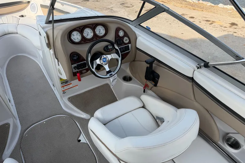 Slide: The Image of 2006 Four Winns 220 Horizon boat interior with steering wheel and dashboard controls. - 10