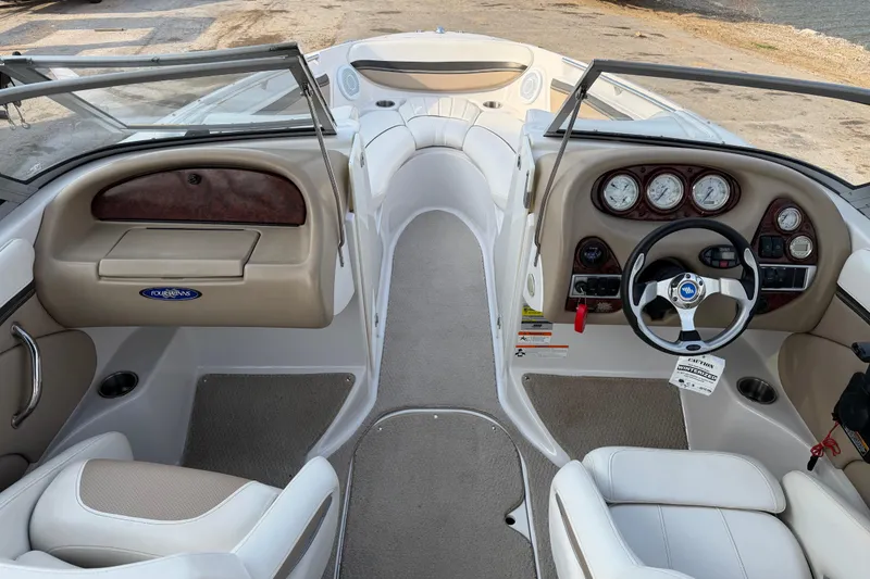 Slide: The Image of 2006 Four Winns 220 Horizon boat interior with steering wheel and dashboard controls. - 11