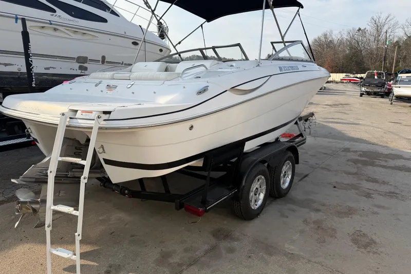 Slide: The Image of 2006 Four Winns 220 Horizon boat on trailer with ladder, parked outdoors. - 4