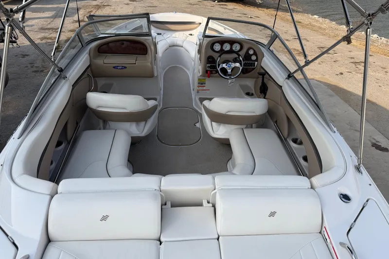 Slide: The Image of 2006 Four Winns 220 Horizon boat interior with white seating and dashboard view. - 6