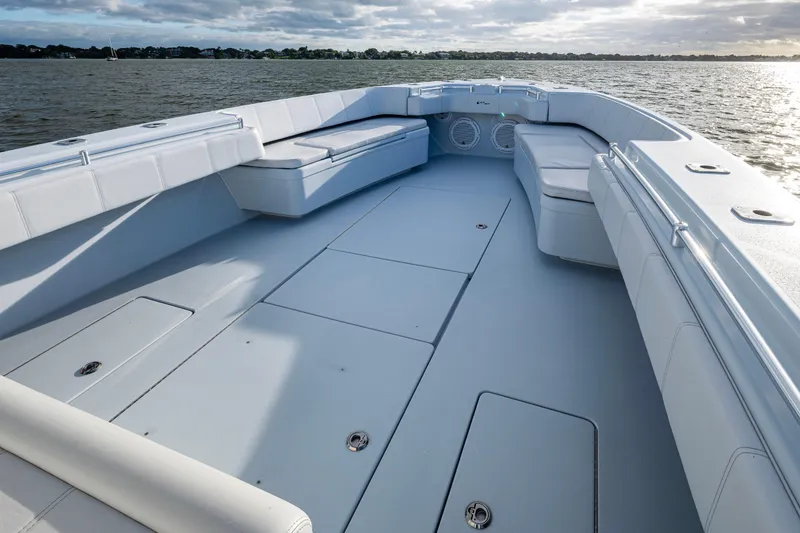 Slide: The Image of 2024 Contender 44 ST boat deck with spacious seating and storage, on calm waters. - 15