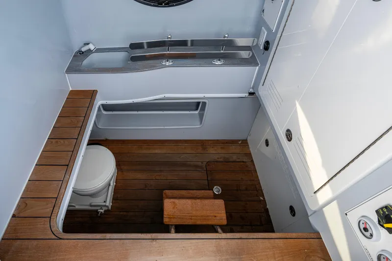 Slide: The Image of 2024 Contender 44 ST boat interior with wooden flooring and compact bathroom amenities. - 20