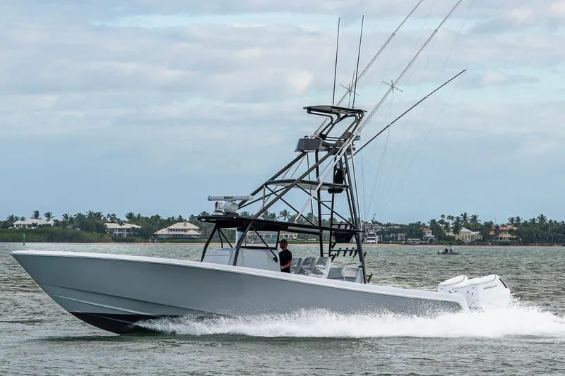 Slide: The Image of 2024 Contender 44 ST boat cruising on water with scenic coastal background. - 35