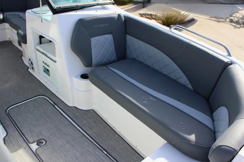 Slide: The Image of 2024 NauticStar 203 DC Deck boat interior with gray seating and storage compartment. - 18