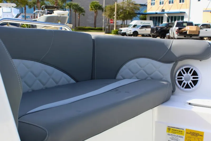Slide: The Image of 2024 NauticStar 203 DC Deck boat with gray cushioned seating and speaker. - 29