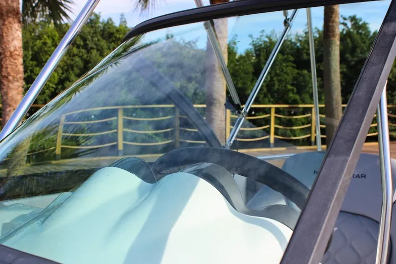 Slide: The Image of 2024 NauticStar 203 DC Deck boat interior with steering wheel and windshield. - 32
