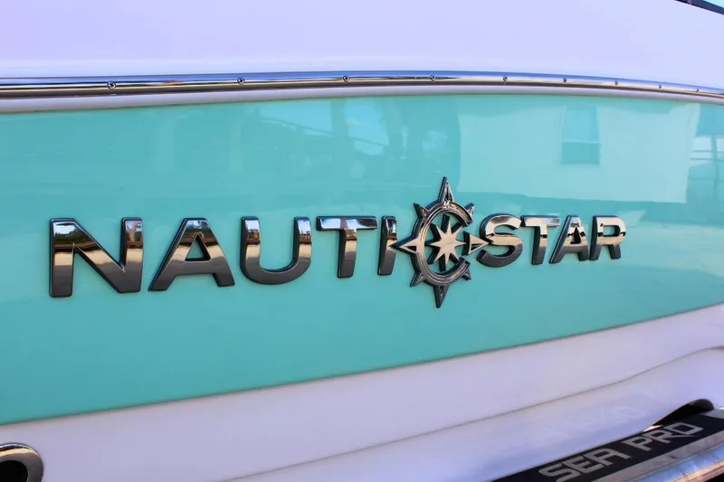 Slide: The Image of 2024 NauticStar 203 DC Deck boat logo on turquoise hull. - 4