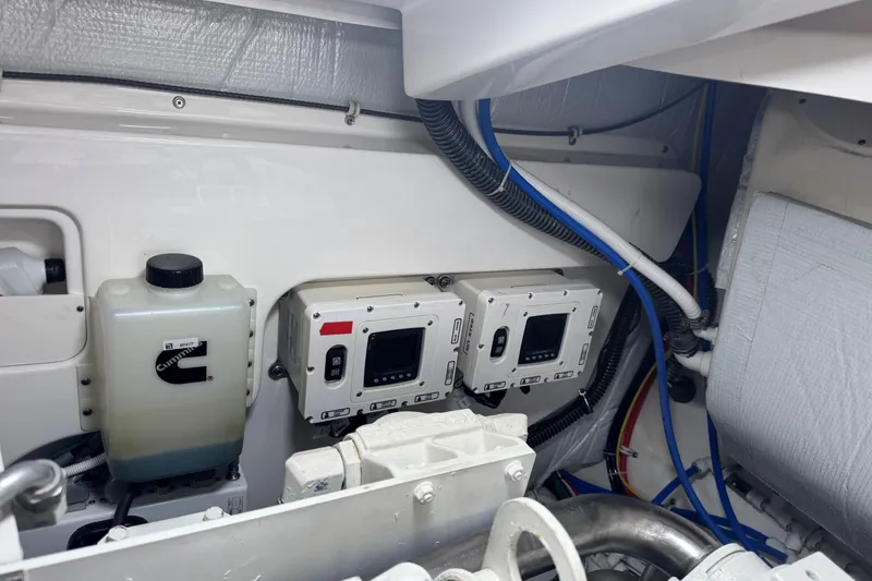 Slide: The Image of Engine room of 2022 Tiara Yachts 43 Open, featuring Cummins components and control panels. - 12