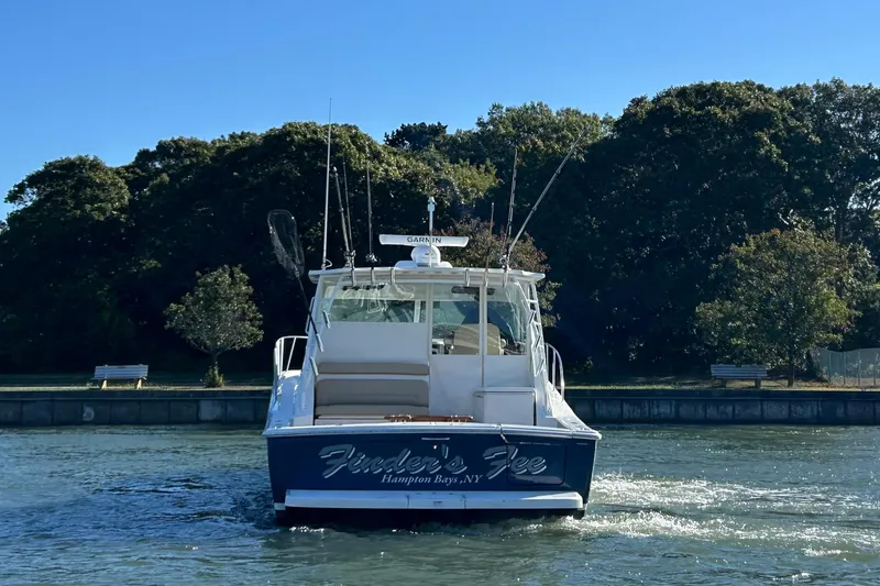 Slide: The Image of 2022 Tiara Yachts 43 Open boat on water, Hampton Bays, NY, surrounded by trees. - 3