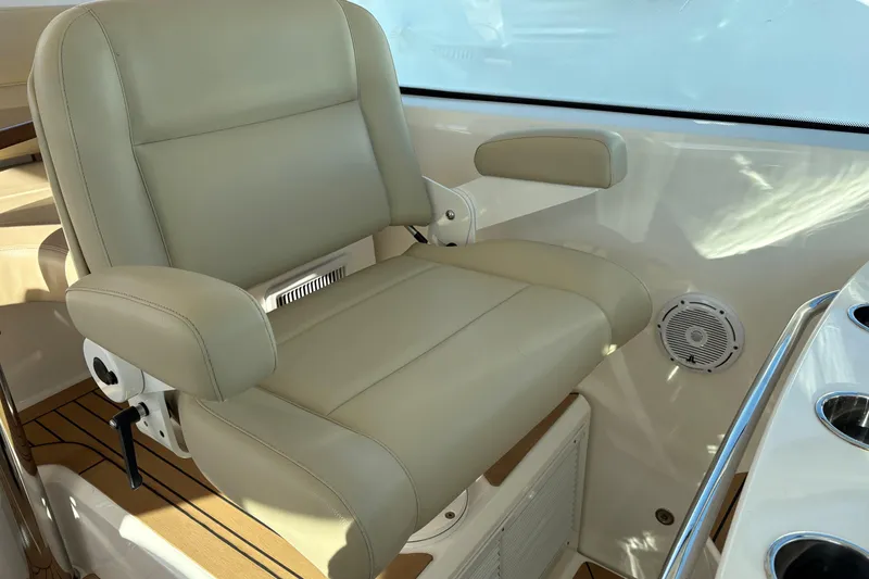 Slide: The Image of Luxury helm seat on 2022 Tiara Yachts 43 Open, featuring beige leather and armrests. - 35