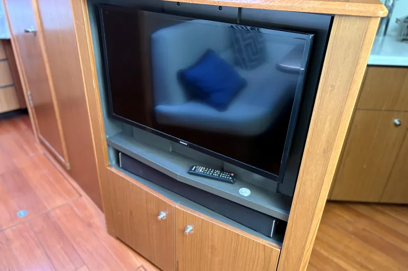 Slide: The Image of Entertainment center with TV and remote on Tiara Yachts 43 Open, 2022 model. - 39