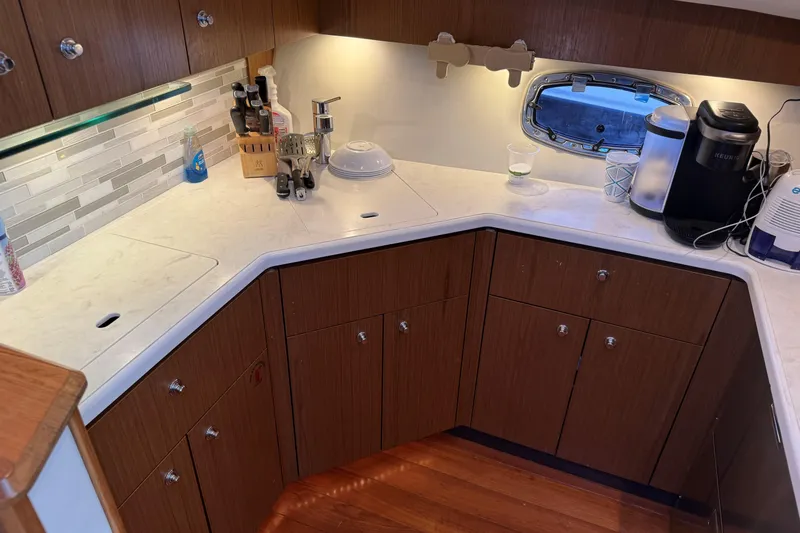 Slide: The Image of Modern kitchen in 2022 Tiara Yachts 43 Open, featuring wood cabinets and sleek countertops. - 40