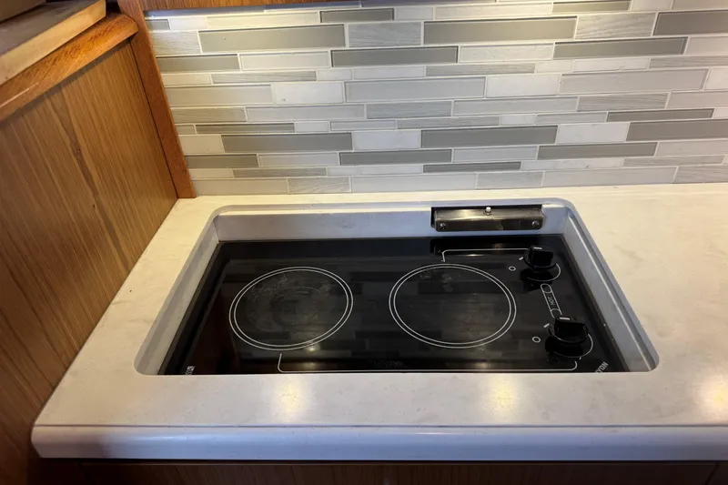 Slide: The Image of Modern kitchen cooktop on 2022 Tiara Yachts 43 Open, featuring sleek design and backsplash. - 41