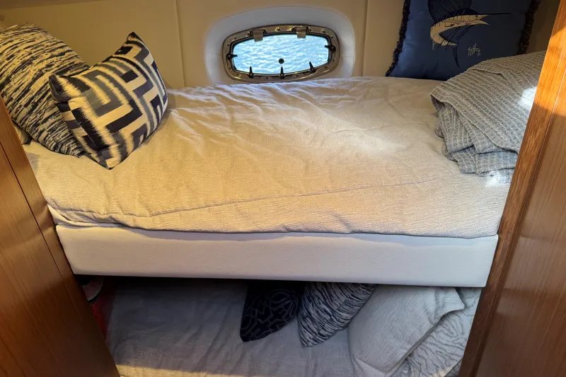 Slide: The Image of Cozy cabin interior of 2022 Tiara Yachts 43 Open with stylish bedding and porthole. - 44