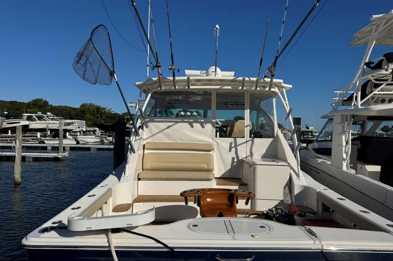 Slide: The Image of 2022 Tiara Yachts 43 Open at marina, equipped for fishing, clear blue sky. - 5