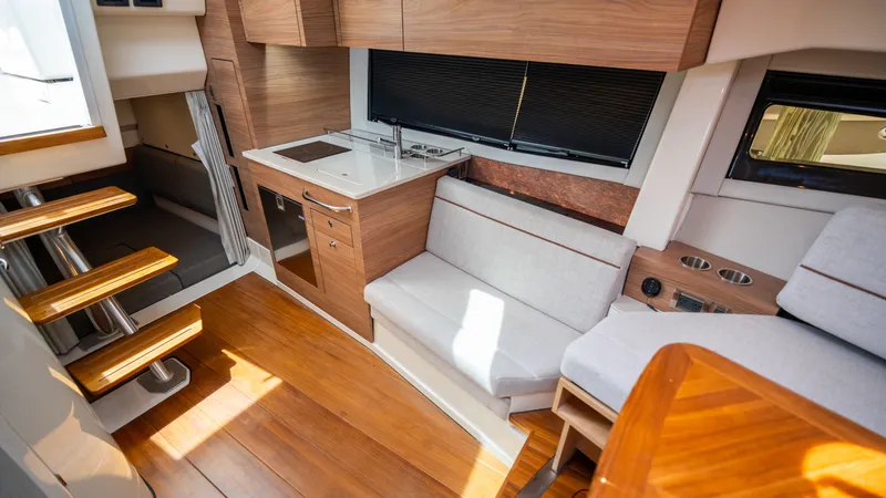Slide: The Image of Interior of 2026 Boston Whaler 365 Conquest yacht, modern kitchen and seating area. - 23