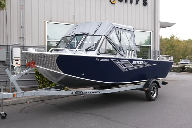 The Image of 2025 Hewescraft 200 Sportsman boat on trailer outside dealership. - 1