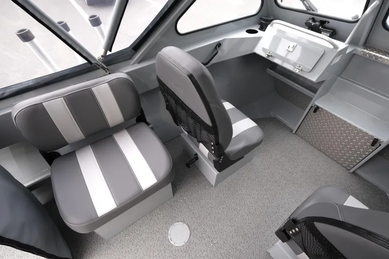 Slide: The Image of Interior of 2025 Hewescraft 200 Sportsman boat with gray seating and storage compartments. - 10