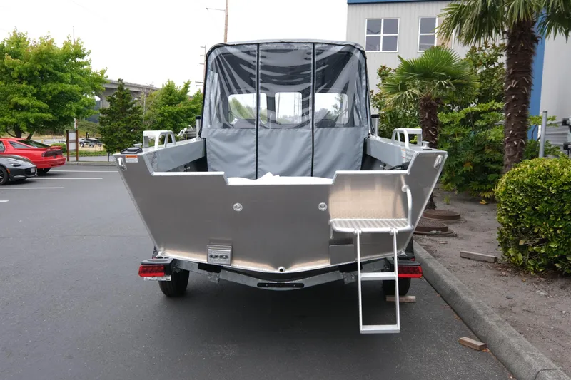 Slide: The Image of 2025 Hewescraft 200 Sportsman boat, rear view in parking lot with greenery. - 5