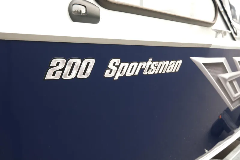 Slide: The Image of 2025 Hewescraft 200 Sportsman boat, close-up of model name on blue hull. - 6