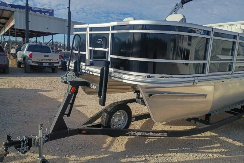 Slide: The Image of 2026 SunCatcher Select 18F pontoon boat on trailer in outdoor setting. - 12