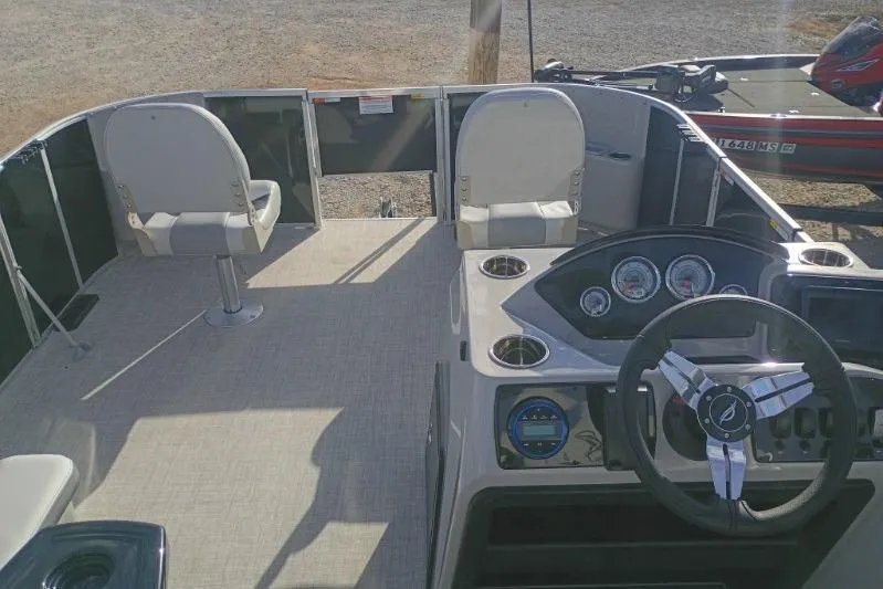 Slide: The Image of 2026 SunCatcher Select 18F boat interior with steering console and seating. - 7