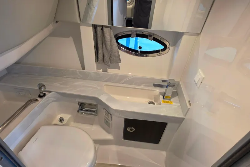 Slide: The Image of 2026 Formula 350 Crossover Bowrider I/O bathroom with modern sink, toilet, and porthole window. - 27