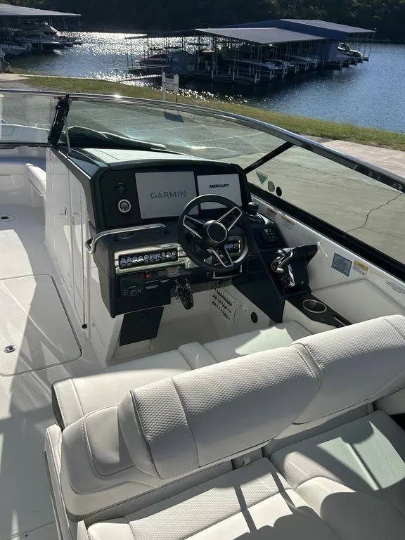 Slide: The Image of 2025 Formula 310 Bowrider boat interior with modern dashboard and lake view. - 18