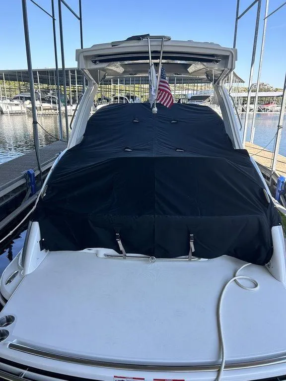 Slide: The Image of 2025 Formula 310 Bowrider docked, covered with a black tarp, American flag displayed. - 29