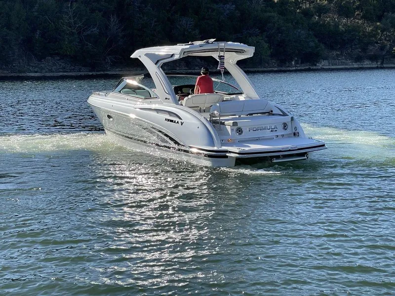 Slide: The Image of 2025 Formula 310 Bowrider cruising on a serene lake with lush forest backdrop. - 8