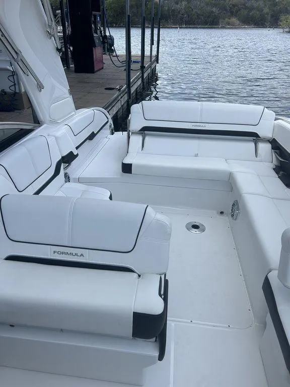 Slide: The Image of 2025 Formula 290 Bowrider boat with spacious seating, docked by a serene lake. - 11