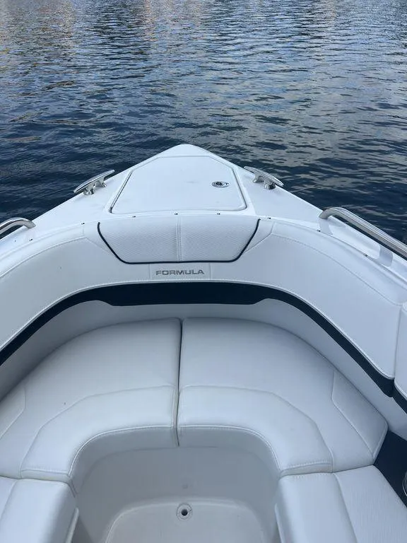 Slide: The Image of 2025 Formula 290 Bowrider anchor compartment with winch and chain, on calm water. - 15