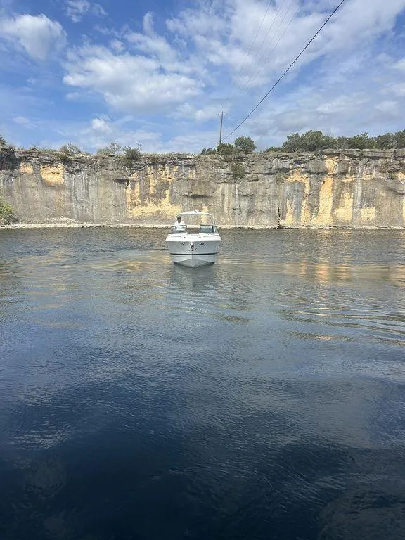 Slide: The Image of 2025 Formula 290 Bowrider cruising on a scenic lake with rocky cliffs. - 2