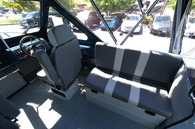 Slide: The Image of Interior of 2025 Hewescraft 210 Sea Runner ET boat, featuring seating and steering area. - 10
