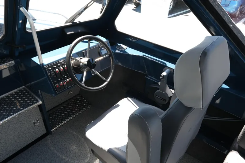 Slide: The Image of Interior of 2025 Hewescraft 210 Sea Runner ET boat, featuring steering wheel and control panel. - 11