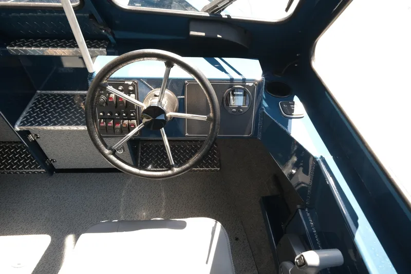 Slide: The Image of Interior of 2025 Hewescraft 210 Sea Runner ET boat, featuring steering wheel and control panel. - 12