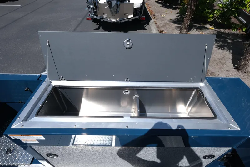 Slide: The Image of 2025 Hewescraft 210 Sea Runner ET boat storage compartment open, showcasing stainless steel interior. - 16