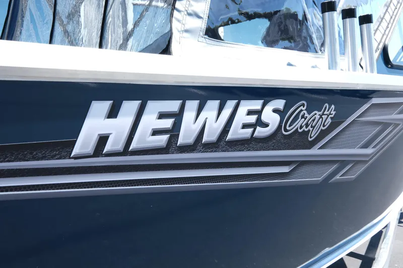 Slide: The Image of 2025 Hewescraft 210 Sea Runner ET boat logo on dark blue hull. - 17