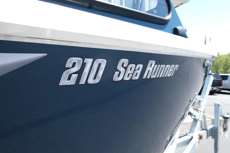Slide: The Image of 2025 Hewescraft 210 Sea Runner ET boat side view with logo. - 5