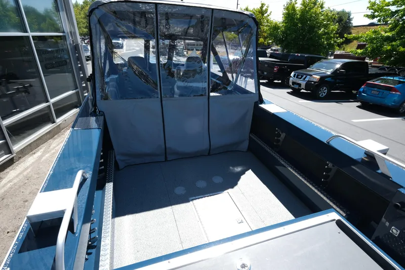 Slide: The Image of 2025 Hewescraft 210 Sea Runner ET boat with covered seating area, parked outdoors. - 6