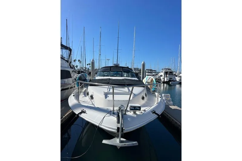 The Image of 1997 Sea Ray 450 Sundancer yacht docked at marina under clear blue sky. - 0